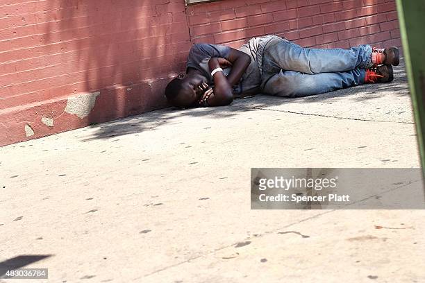 Man who is high on K2 or "Spice", a synthetic marijuana drug, sleeps along a street in East Harlem on August 5, 2015 in New York City. New York,...