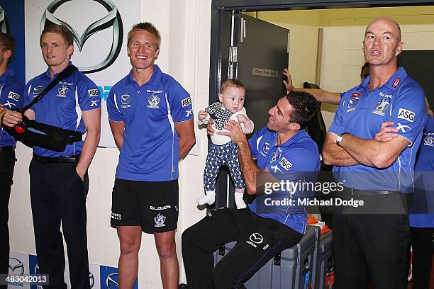 Michael Furrito of the Kangaroos celebrates their win with his baby during the round three AFL match between the North Melbourne Kangaroos and the...