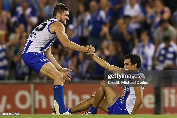 Aaron Black of the Kangaroos and Lindsay Thomas celebrate their win on the siren during the round three AFL match between the North Melbourne...