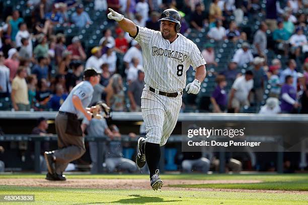 Michael McKenry of the Colorado Rockies celebrates as he rounds the bases on his walk off two run game winning home run off of Mayckol Guaipe of the...
