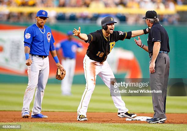 Neil Walker of the Pittsburgh Pirates argues a call with umpire Paul Nauert that he ran out of the base path during a rundown with Addison Russell of...