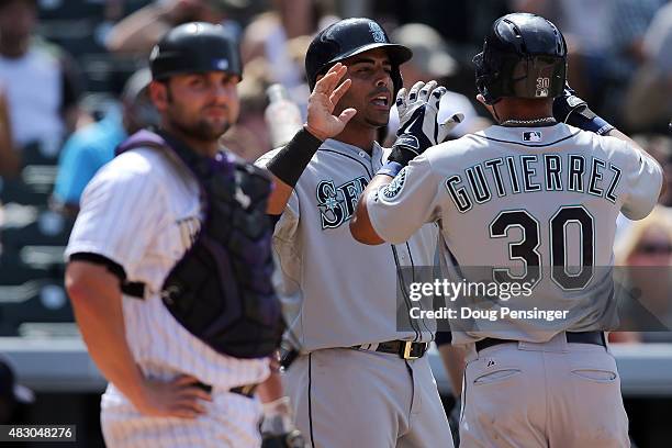 Franklin Gutierrez of the Seattle Mariners celebrates his two run home run with Nelson Cruz of the Seattle Mariners as catcher Michael McKenry of the...