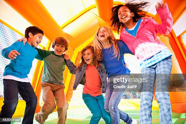 children in bounce house - inflatable playground stock pictures, royalty-free photos & images