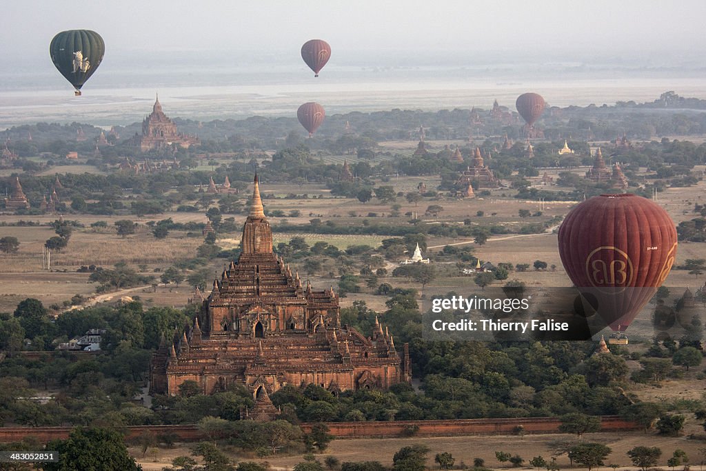 Hot-air balloons fly at dawn over the Bagan archaeological...
