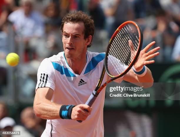 Andy Murray of Great Britain plays a backhand volley during his straight sets defeat in the fourth rubber by Fabio Fognini of Italy during day three...