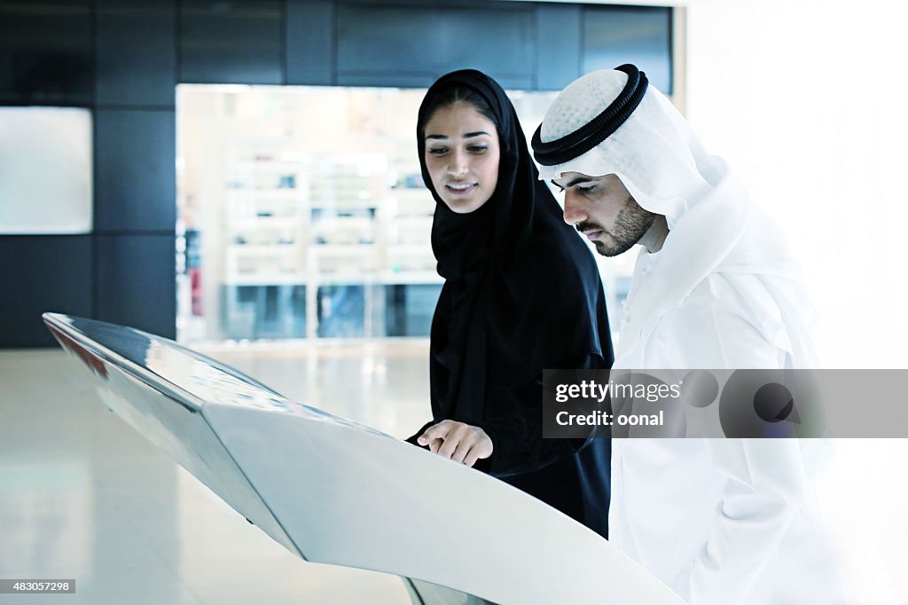 Arab família usando digital ecrã de quiosque interactivo
