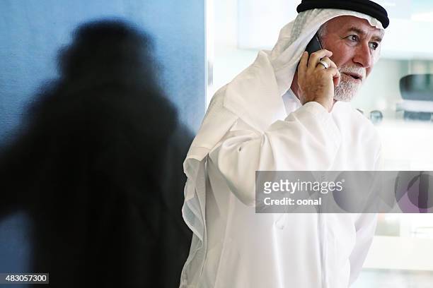 arabian man talking on phone - old saudi man stock pictures, royalty-free photos & images