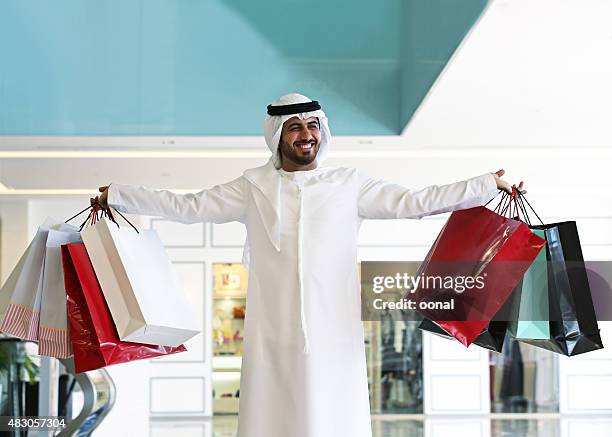 arab man in shopping center with bags - arab shopping stockfoto's en -beelden