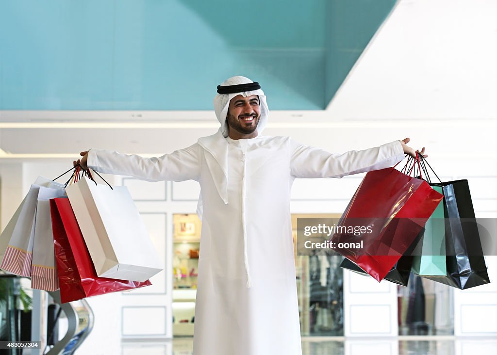 Homem Árabe com sacos em shopping center