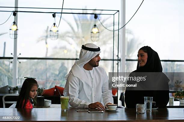 arabian family enjoying leisure time in a cafe - qatari family stockfoto's en -beelden