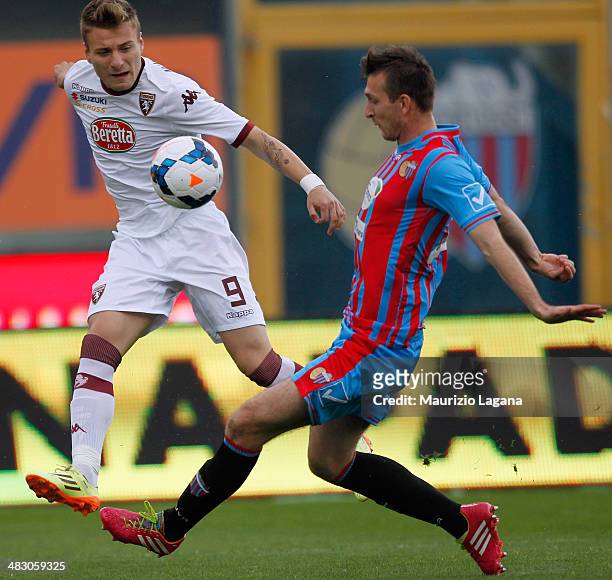 Norbert Gyomber of Catania competes for the ball with Ciro Immobile of Torino during the Serie A match between Calcio Catania and Torino FC at Stadio...