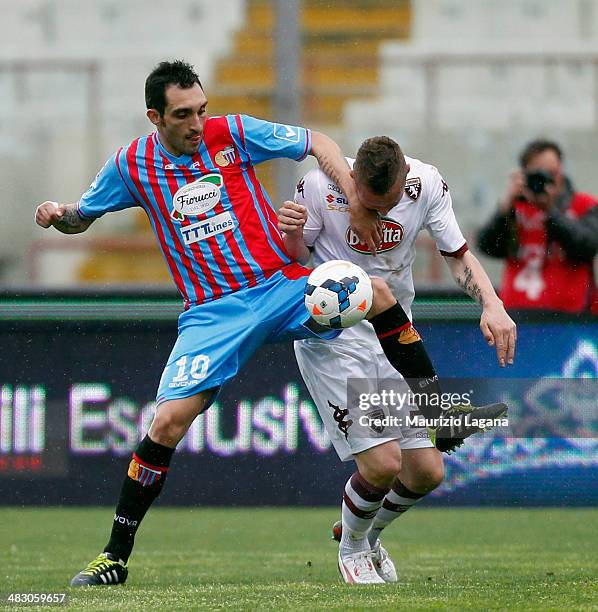 Francesco Lodi of Catania competes for the ball with Jasmine Kurtic of Torino during the Serie A match between Calcio Catania and Torino FC at Stadio...