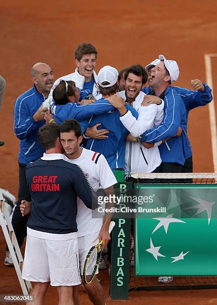 James Ward of Great Britain is consoled by his team captain Leon Smith after losing the fifth and decisive rubber to Andreas Seppi of Italy during...
