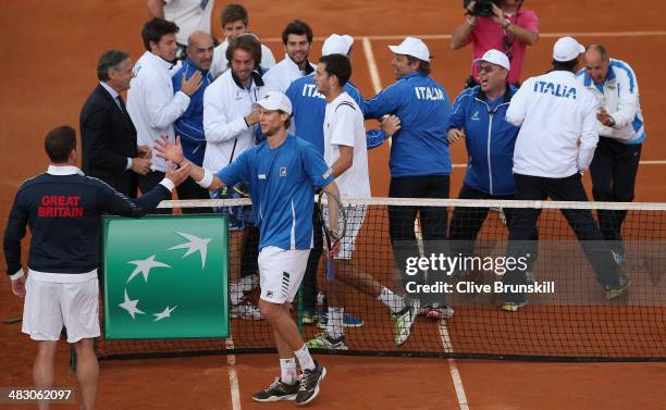 British team captain Leon Smith shakes hands and congratulates Andreas Seppi of Italy after winning the fifth and decisive rubber against James Ward...