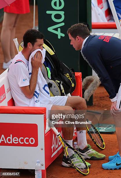 James Ward of Great Britain listens to advice from his team captain Leon Smith during the fifth and decisive rubber against Andreas Seppi of Italy...