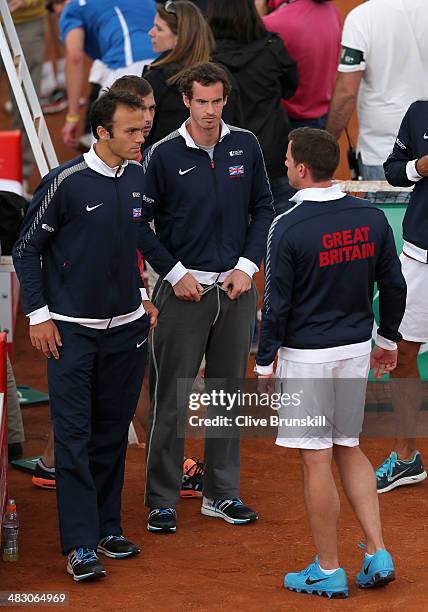 Andy Murray and Ross Hutchins of Great Britain talk with their team captain Leon Smith after team mate James Ward has lost the fifth and decisive...