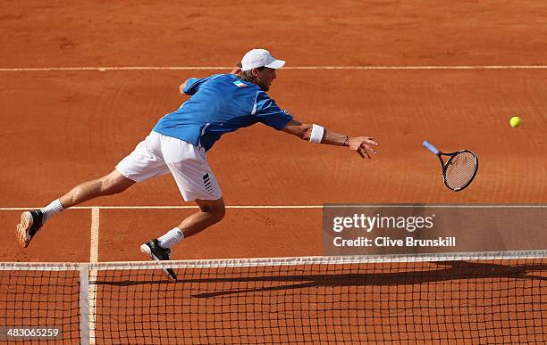 Andreas Seppi of Italy throws his racket to the ball after missing a backhand volley during the fifth and decisive rubber against James Ward of Great...