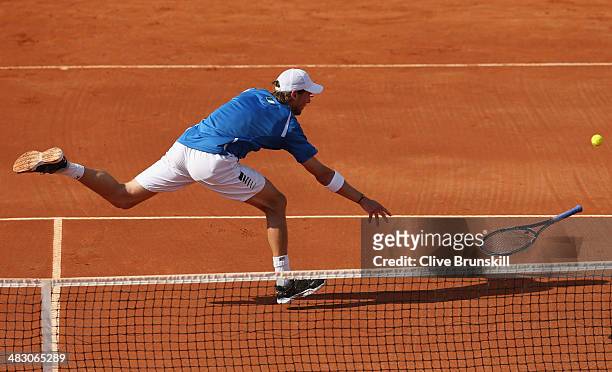 Andreas Seppi of Italy throws his racket to the ball after missing a backhand volley during the fifth and decisive rubber against James Ward of Great...