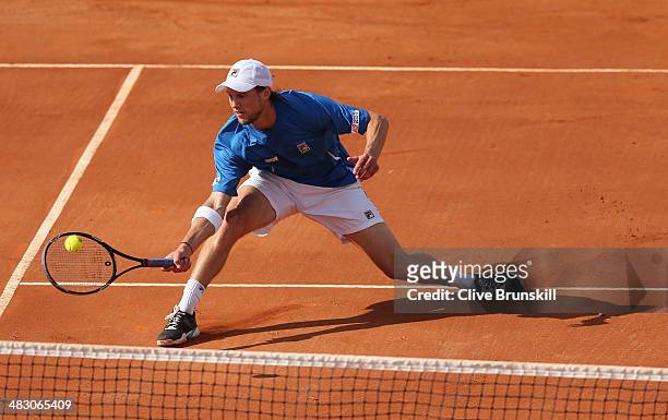 Andreas Seppi of Italy slides to play a forehand volley during the fifth and decisive rubber against James Ward of Great Britain during day three of...