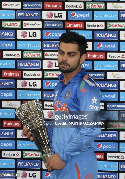 Indian cricketer Virat Kohli poses with the Man of the Series trophy following the ICC World Twenty20 cricket tournament final match between India...