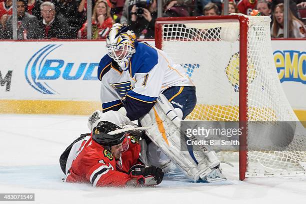 Marcus Kruger of the Chicago Blackhawks slides into goalie Brian Elliott of the St. Louis Blues during the NHL game on April 06, 2014 at the United...