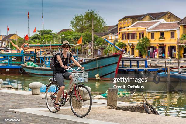 woman tourist cycling in hoi an city, vietnam - hoi an stockfoto's en -beelden