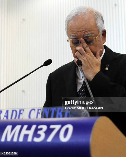 This picture taken early on August 6, 2015 shows Malaysia's Prime Minister Najib Razak adjusting his glasess before delivering a statement during a...