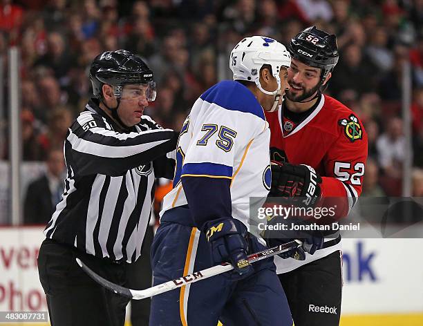 Brandon Bollig of the Chicago Blackhawks has words with Ryan Reeves of the St. Louis Blues as liesman Scott Cherrey moves to separate them at the...