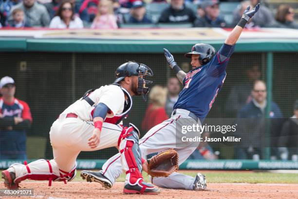 Catcher Yan Gomes of the Cleveland Indians waits for the throw as Jason Bartlett is safe at home off a double by Chris Colabello of the Minnesota...