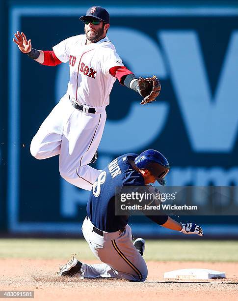 Dustin Pedroia of the Boston Red Sox attempts to catch the throw from teammate David Ross on an attempted steal by Ryan Braun of the Milwaukee...