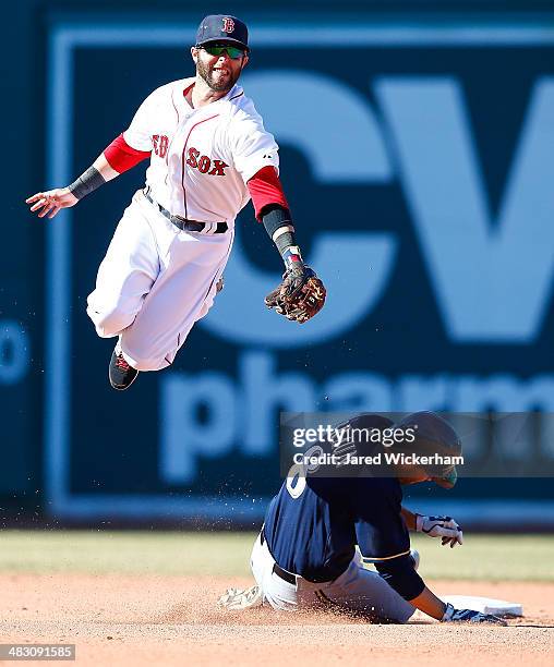 Dustin Pedroia of the Boston Red Sox attempts to catch the throw from teammate David Ross on an attempted steal by Ryan Braun of the Milwaukee...