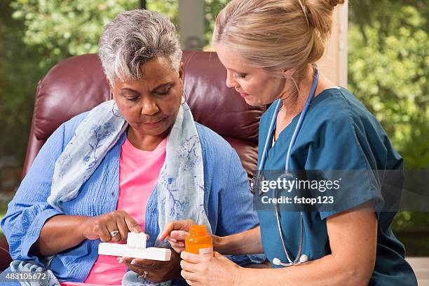 home healthcare nurse with senior adult patient. medications. - pillen nemen stockfoto's en -beelden