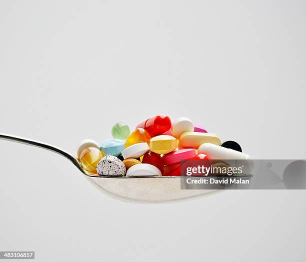 spoon full of pills - nutritional supplement fotografías e imágenes de stock