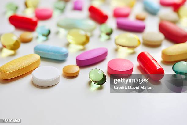 various pills lying on a white surface - pill - fotografias e filmes do acervo