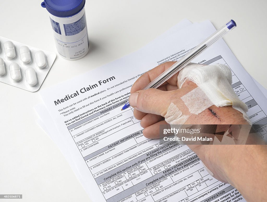 Injured hand filling in a medical claim form