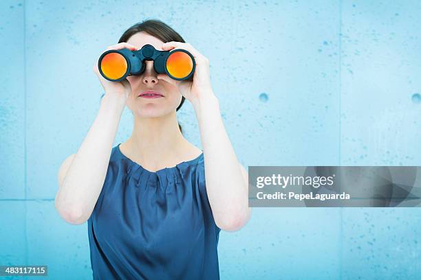 businesswoman holding binoculars - zoeken stockfoto's en -beelden