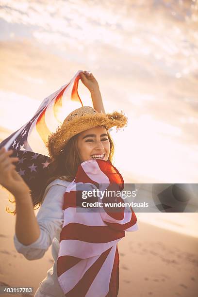 proud american girl holding stars and stripes - american flag beach stock pictures, royalty-free photos & images