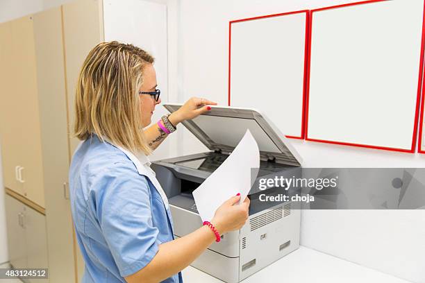 cute young nurse with tatoo on her forearm at work. - faxmachine stockfoto's en -beelden