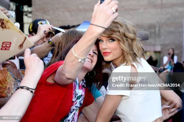 Recording artist Taylor Swift takes a selfie photo with fans during the red carpet at the 49th Annual Academy of Country Music Awards at the MGM...