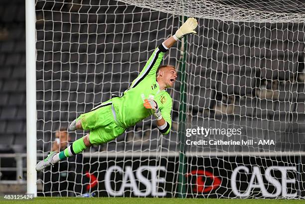 Cody Cropper of MK Dons dives during the pre-season friendly between MK Dons and a Chelsea XI at Stadium mk on August 3, 2015 in Milton Keynes,...