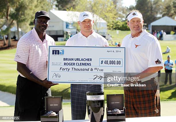 Legend Michael Jordan presents former NFL player Brian Urlacher and Roger Clemens with a check for $40,000 after they won Aria Resort & Casino's 13th...