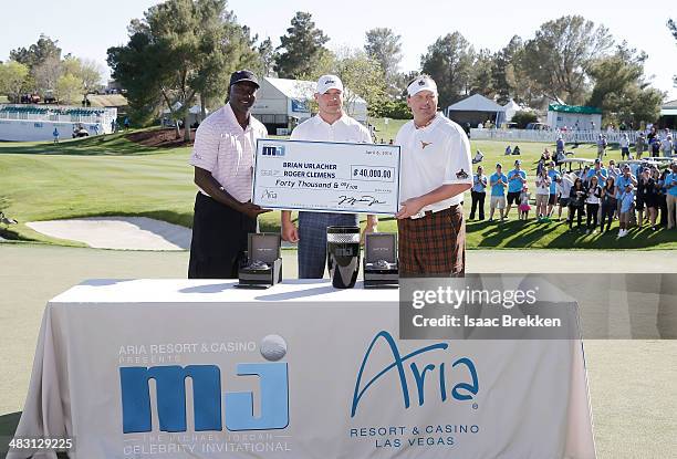 Legend Michael Jordan presents former NFL player Brian Urlacher and Roger Clemens with a check for $40,000 after they won Aria Resort & Casino's 13th...