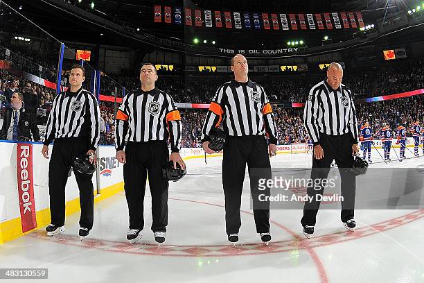 Officials; Kiel Murchison, Marc Joannette, Kevin Pollock and Jay Sharrers stand for the singing of the national anthem prior to a game between the...