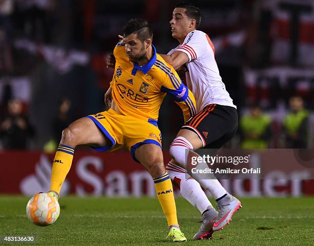 Andre Pierre Gignac of Tigres fights for the ball with Ramiro Funes Mori of River Plate during a second leg final match between River Plate and...