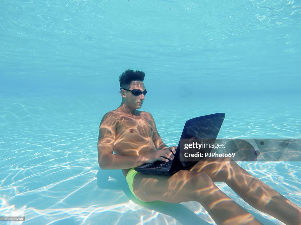 Young man using computer underwater