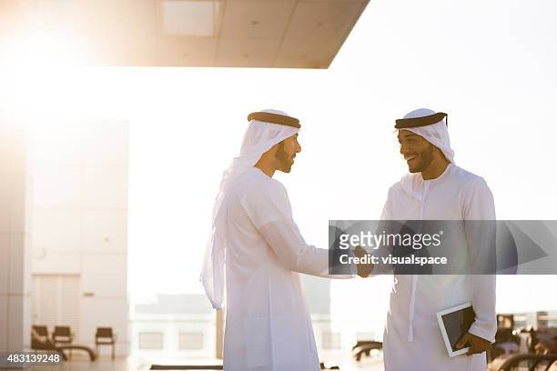 zwei arabische mann händeschütteln - gulf countries stock-fotos und bilder