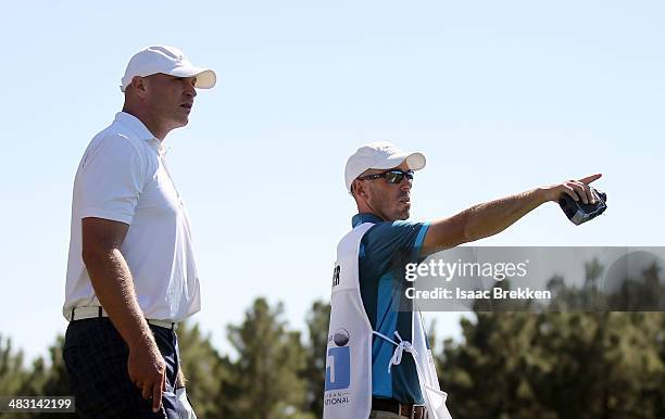 Former NFL player Brian Urlacher lines up a shot with his caddie during Aria Resort & Casino's 13th Annual Michael Jordan Celebrity Invitational at...