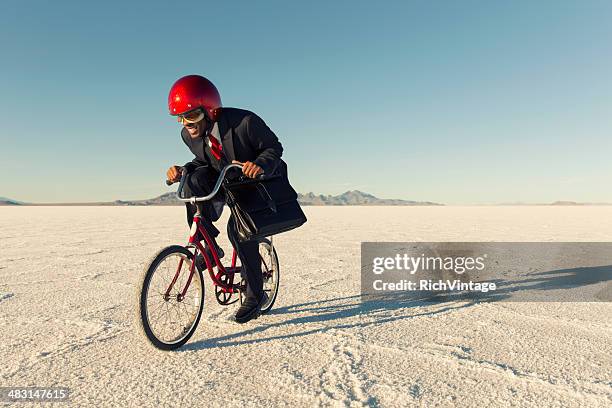 man in business suit and racing helmet races his bicycle - turnover sport 個照片及圖片檔