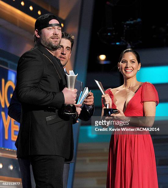 Singer Lee Brice accepts the Song of the Year award for 'I Drive Your Truck' onstage from NFL quarterback Aaron Rodgers and actress Olivia Munn...