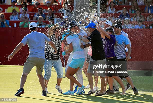 Lexi Thompson of the USA and her brother caddie Benji Thompson are soaked by family and friends on the 18th green after her three shot win during the...